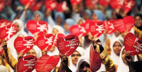 Muslim women shout a slogan as they show placards during the Anti-Valentine's Day Campaign in Putrajaya